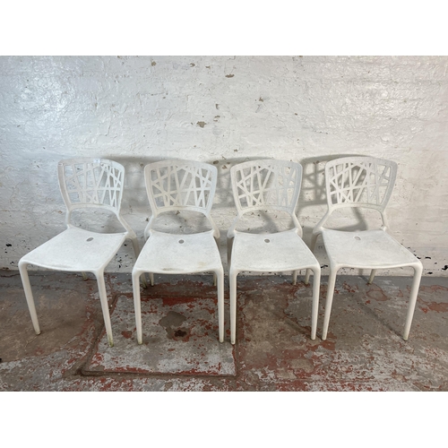 125 - Four white plastic stacking chairs