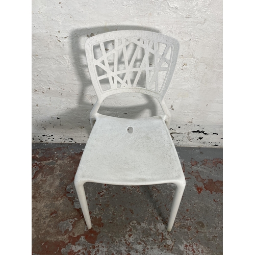 125 - Four white plastic stacking chairs