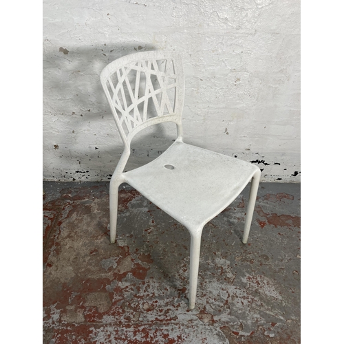 125 - Four white plastic stacking chairs