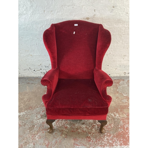 126 - A mid 20th century Parker Knoll PK976 red fabric upholstered wingback armchair on cabriole supports