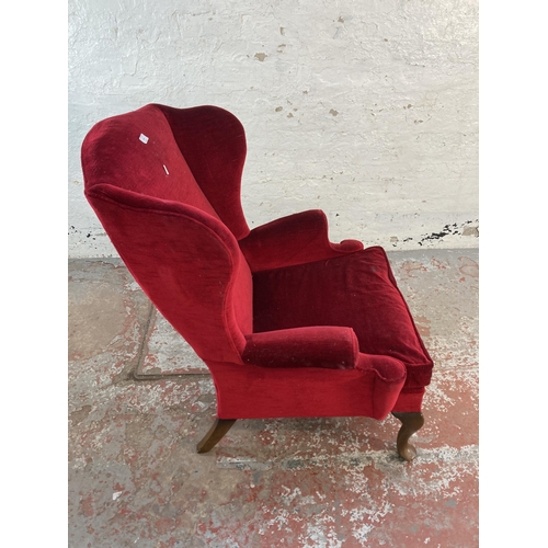 126 - A mid 20th century Parker Knoll PK976 red fabric upholstered wingback armchair on cabriole supports