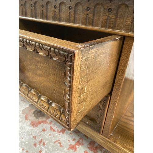 13 - A carved oak rectangular two tier coffee table - approx. 46cm high x 48cm wide x 101cm long