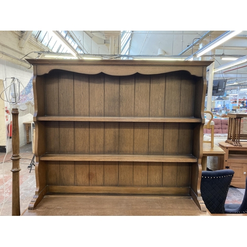 145 - An L. Marcus Ltd. carved oak linenfold dresser - approx. 184cm high x 121cm wide x 48cm deep