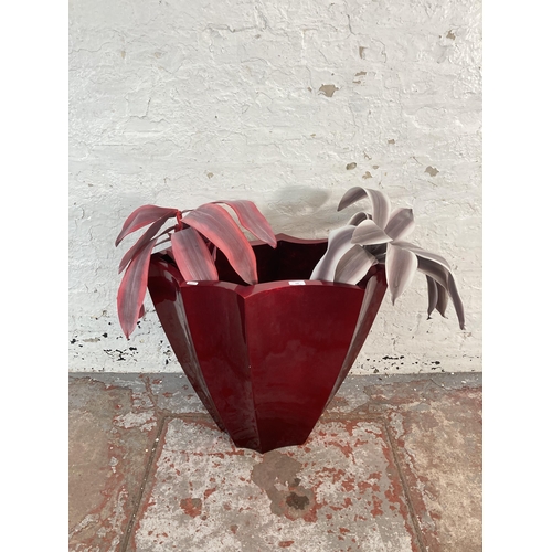 168 - A modern red fibreglass planter with two artificial plants - approx. 61cm high