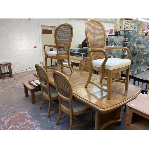 188 - An Art Deco style oak and beech extending dining table and six rattan back chairs - approx. 76cm hig... 