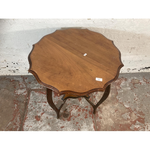 215 - An Edwardian mahogany serpentine two tier occasional table - approx. 70cm high x 65cm diameter