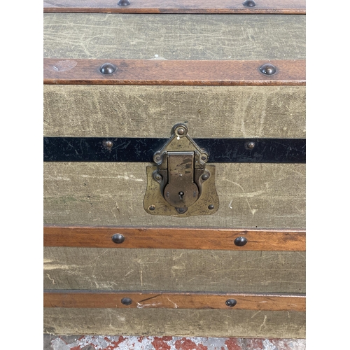 34 - An early 20th century green canvas and wooden banded dome top travel trunk - approx. 56cm high x 85c... 