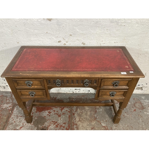 56 - A carved oak writing desk with red leather insert - approx. 73cm high x 107cm wide x 47cm deep