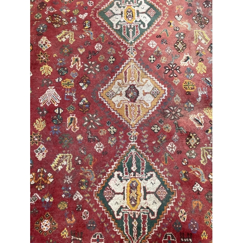 61 - A 20th century red floral pattern rug - approx. 270cm x 180cm