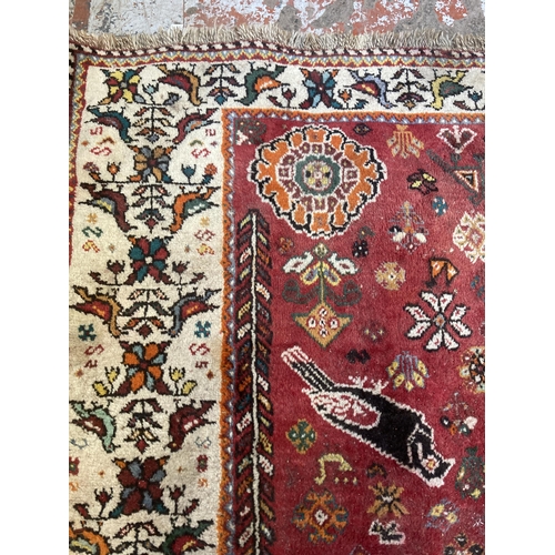 61 - A 20th century red floral pattern rug - approx. 270cm x 180cm