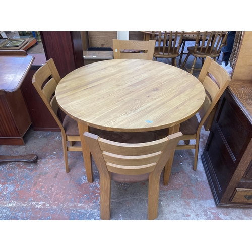 72 - A modern oak circular dining table and four chairs - approx. 78cm high x 110cm diameter