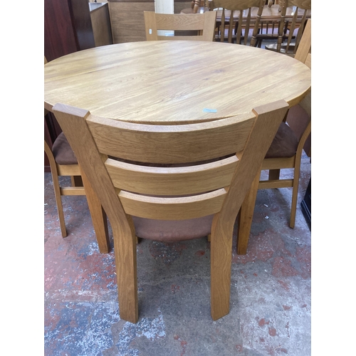 72 - A modern oak circular dining table and four chairs - approx. 78cm high x 110cm diameter