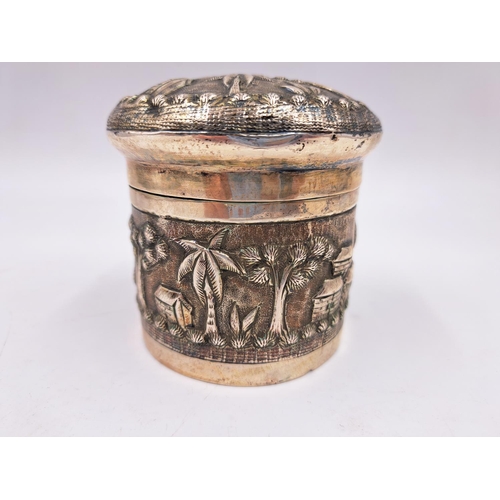 2428 - A late 19th century Indian white metal lidded tea caddy with embossed village scene decoration - app... 