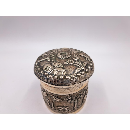 2428 - A late 19th century Indian white metal lidded tea caddy with embossed village scene decoration - app... 