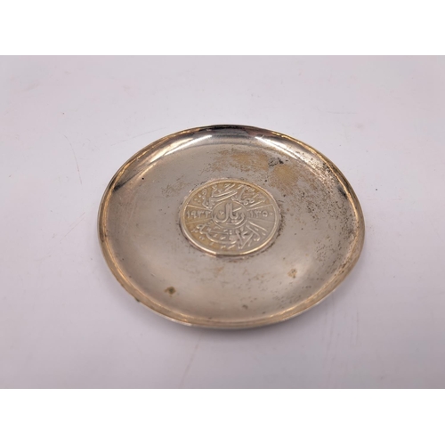 2431 - An Iraqi white metal one riyal coin dish - approx. gross weight 44g and 8.5cm diameter