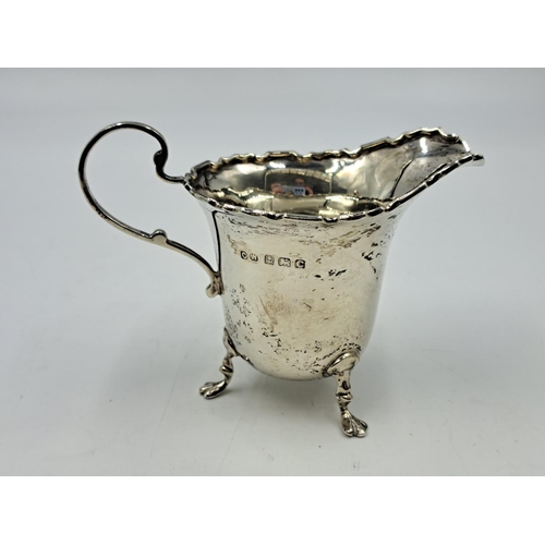 2500 - A George V Charles Weale hallmarked Birmingham silver creamer on tri-footed supports, dated 1927 - a... 