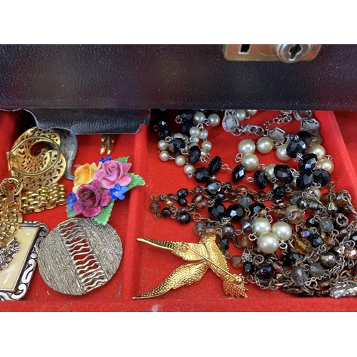 965 - A vintage jewellery box containing a collection of costume jewellery and wristwatches to include yel... 