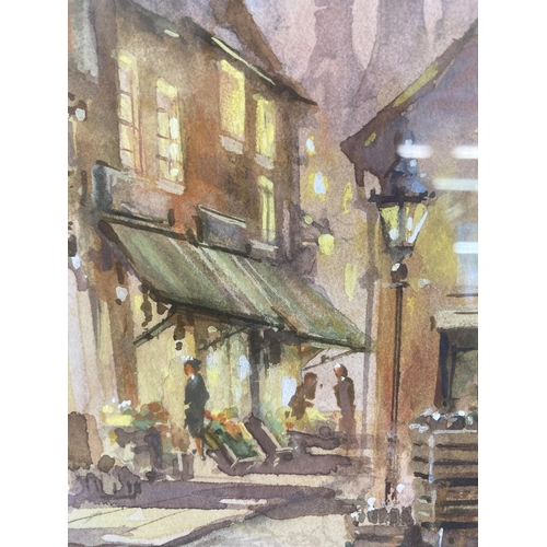 264 - A gilt framed watercolour of a street scene signed lower left - approx. 36cm high x 30cm wide