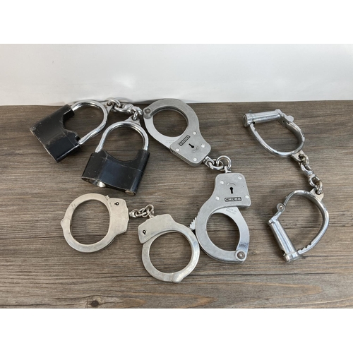 1109 - A collection of vintage handcuffs to include Hiatt, Chubb etc.