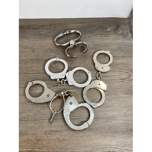 1109 - A collection of vintage handcuffs to include Hiatt, Chubb etc.