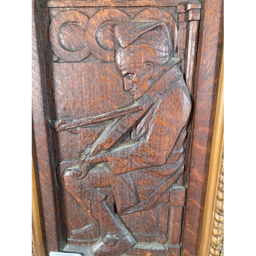 1120 - A carved oak panel of a fiddle player in gilt frame - approx. 35cm high x 23cm wide