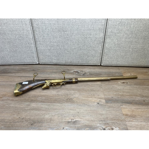 1136 - A vintage brass and hardwood ornamental wall hanging rifle - approx. 98cm long