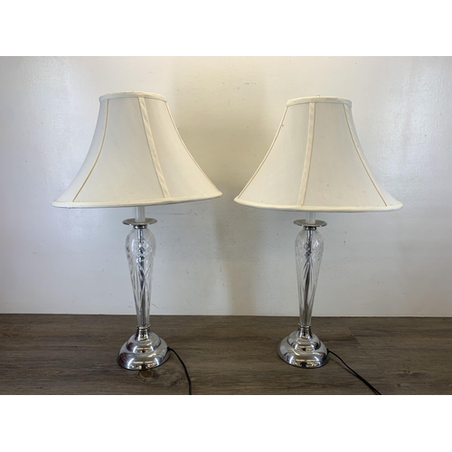 1042 - A pair of contemporary cut glass and chrome plated table lamps with white shades - approx. 73cm high... 