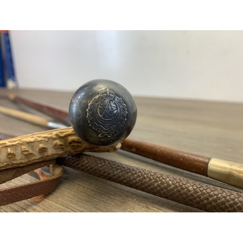 1055 - Five items, one Punjab Regiment Swagger stick with white metal top and cane shaft and four riding cr... 