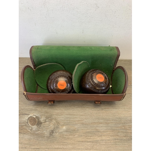 1062 - A pair of brown leather cased Premier Bowls of Stockport crown green bowls