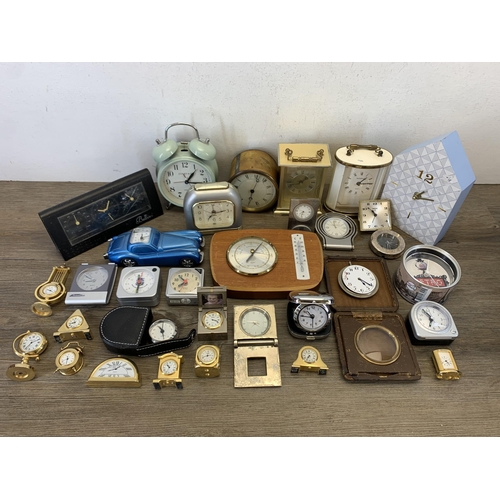 1077 - A large collection of bedside and alarm clocks to include mid 20th century Metamec carriage clock et... 