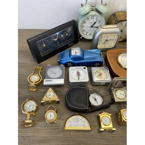 1077 - A large collection of bedside and alarm clocks to include mid 20th century Metamec carriage clock et... 