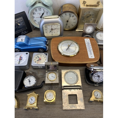 1077 - A large collection of bedside and alarm clocks to include mid 20th century Metamec carriage clock et... 