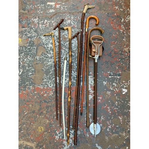 1097 - A collection of vintage walking sticks and canes together with a vintage aluminium and leather shoot... 