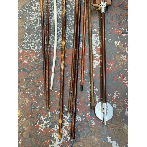 1097 - A collection of vintage walking sticks and canes together with a vintage aluminium and leather shoot... 