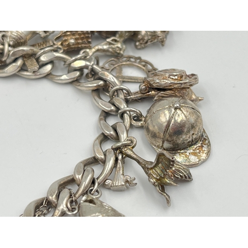 2334 - A hallmarked sterling silver charm bracelet with assorted silver charms - approx. gross weight 82g