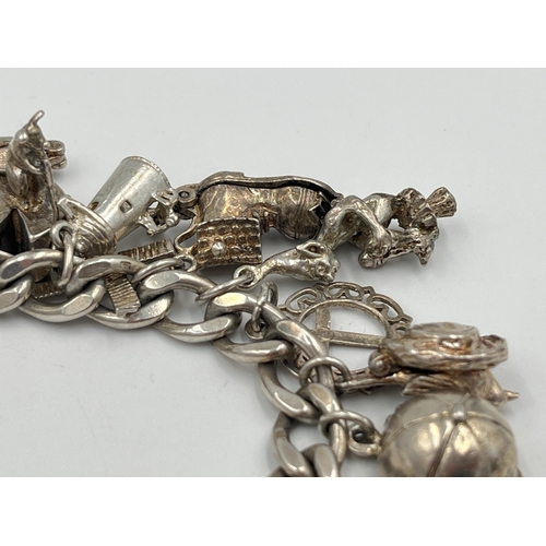 2334 - A hallmarked sterling silver charm bracelet with assorted silver charms - approx. gross weight 82g