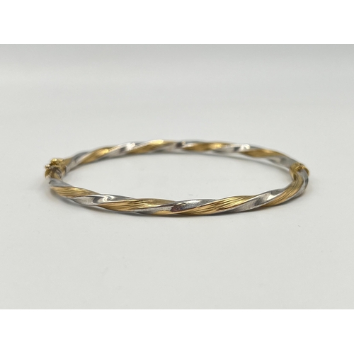 2364 - A 9ct yellow and white gold twisted bangle - approx. gross weight 3.85g