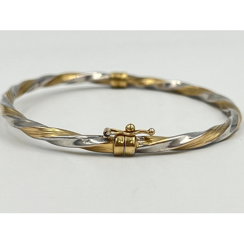 2364 - A 9ct yellow and white gold twisted bangle - approx. gross weight 3.85g