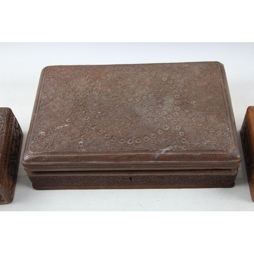 505 - Three Indian carved teak jewellery boxes - largest approx. 8cm high x 29cm wide x 19cm deep