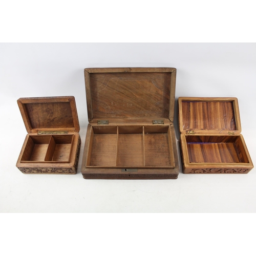 505 - Three Indian carved teak jewellery boxes - largest approx. 8cm high x 29cm wide x 19cm deep