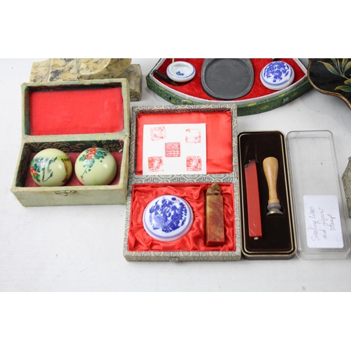 515A - A collection of oriental items to include papier-mache crumb tray, two carved stone dragon ornaments... 