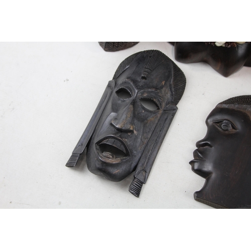 518 - A collection of African ornaments to include tribal masks, ebony busts, hand carved sculptures etc.