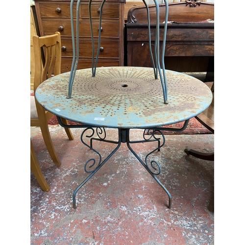 102 - A modern green painted wrought metal three piece patio set comprising circular table and two chairs ... 