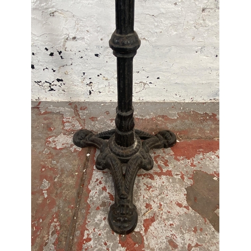 128 - A Victorian cast iron tripod pedestal pub table with later added marble circular top - approx. 73cm ... 