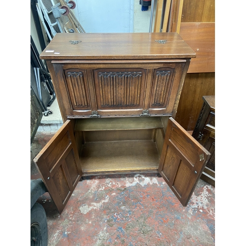 137 - An Old Charm carved oak linenfold cocktail cabinet - approx. 110cm high x 76cm wide x 28cm deep