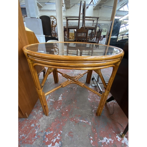 175 - A mid/late 20th century wicker and cane circular dining table with smoked glass top - approx. 78cm h... 