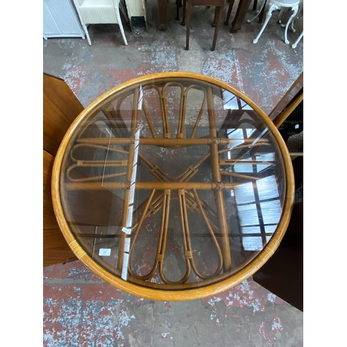 175 - A mid/late 20th century wicker and cane circular dining table with smoked glass top - approx. 78cm h... 