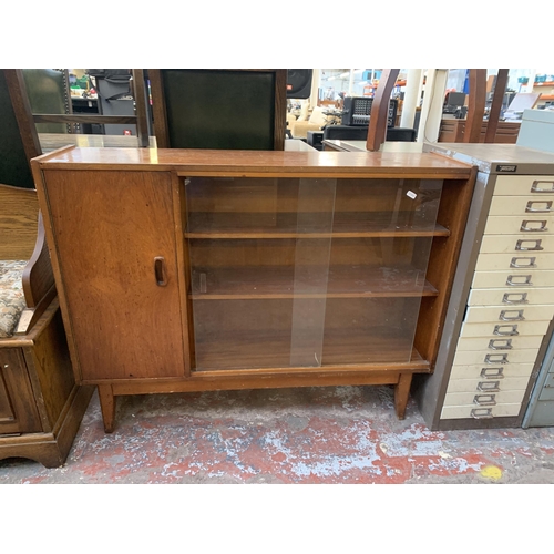 201 - A mid 20th century teak bookcase with two glass sliding doors - approx. 83cm high x 106cm wide x 25c... 