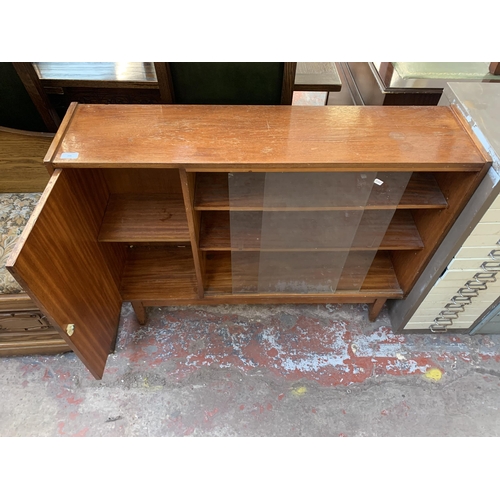 201 - A mid 20th century teak bookcase with two glass sliding doors - approx. 83cm high x 106cm wide x 25c... 