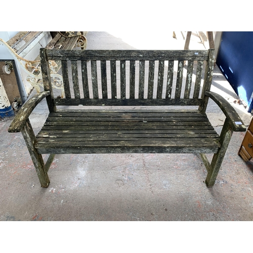 217 - A teak two seater garden bench - approx. 96cm high x 139cm wide x 51cm deep